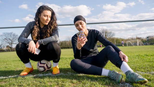 Female footballers looking at the best grassroots football app - STATZO