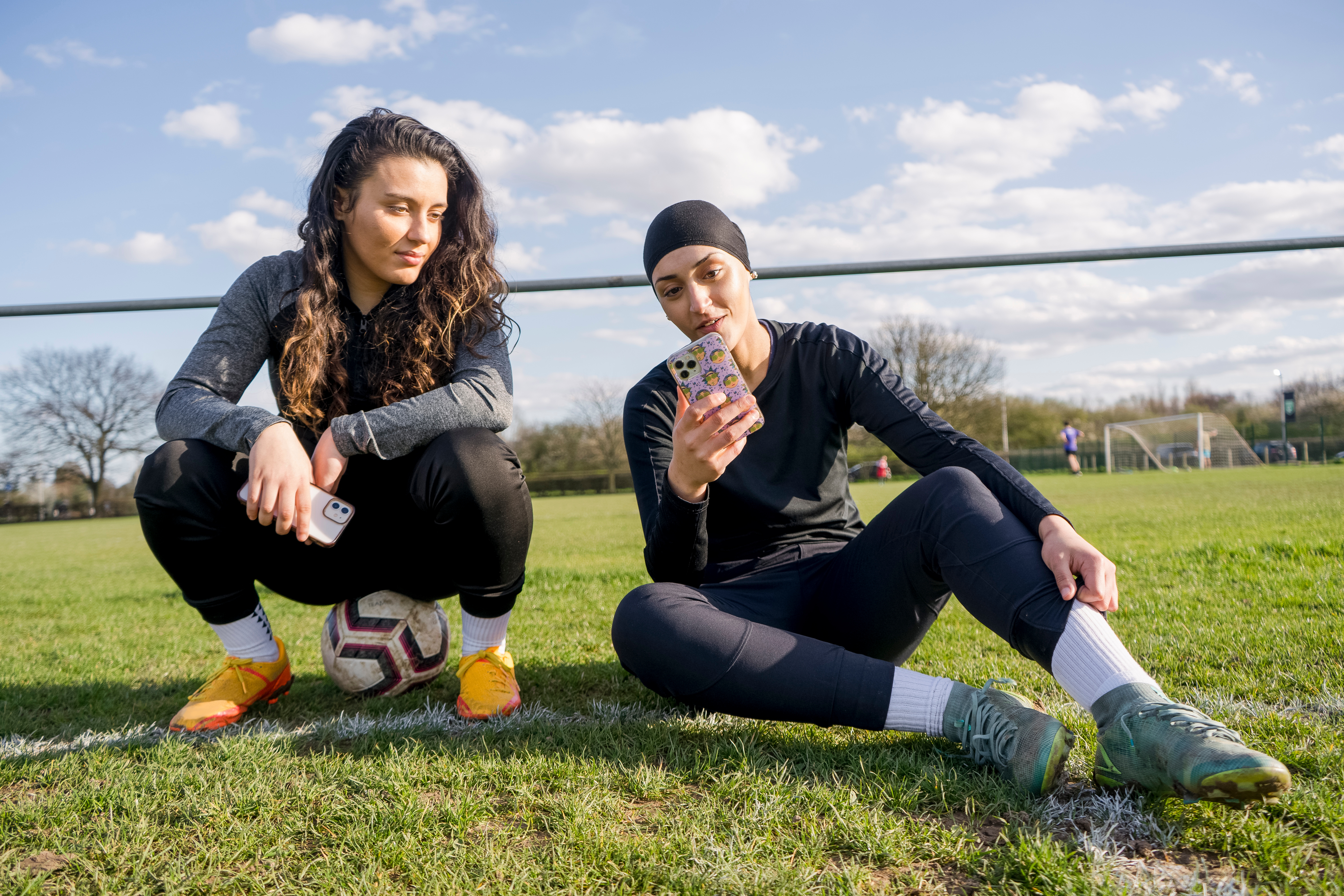 Female footballers looking at the best grassroots football app - STATZO